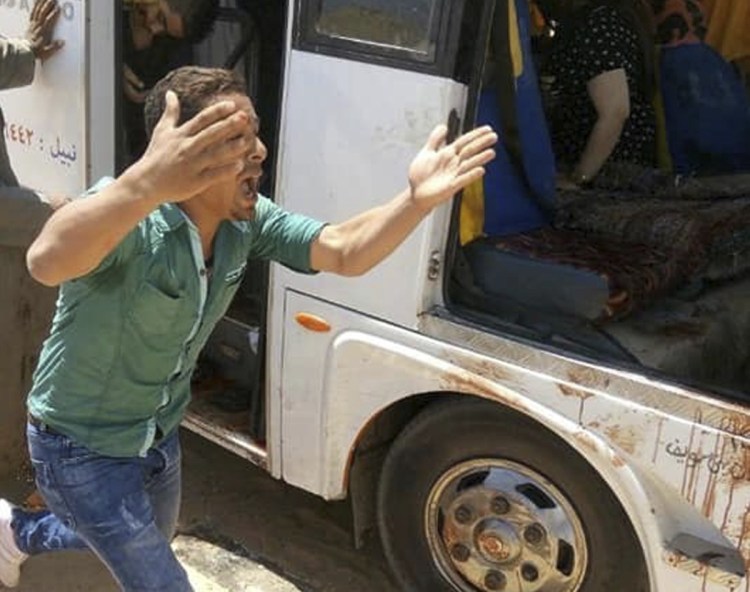 A man screams beside a bus carrying Coptic Christian pilgrims that came under attack by Islamic militants outside Cairo on Friday, killing at least seven and wounding 19 more.