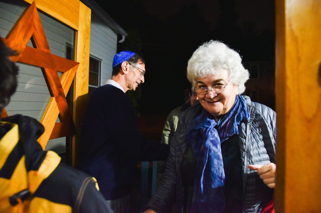 Former Rabbi Susan Bulba Carvutto enters Temple Beth El in Augusta for a Shabbat service on Friday evening, as Michael Dickey greets guests and congregants.