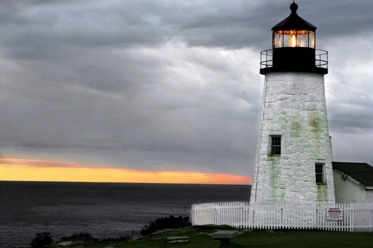 The sun sets behind a layer of clouds at Pemaquid Point Lighthouse in Bristol.