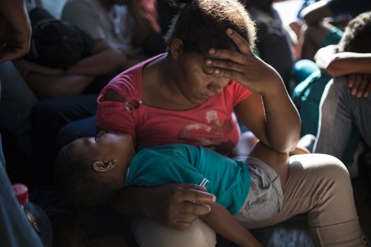 Yamilet Hernandez rests with her son inside a truck between Pijijiapan and Arriaga, Mexico, on Oct. 26. More than 6,000 migrants are traveling through Mexico.
