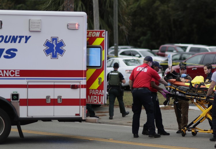 A person is transported from the scene of a shooting Friday in Tallahassee, Fla. A gunman killed two people and critically wounded four others at a yoga studio.
