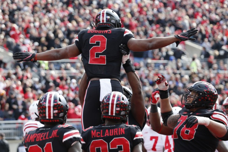 J.K. Dobbins of eighth-ranked Ohio State celebrates with teammates Saturday after scoring a touchdown in the first half of the 36-31 victory against Nebraska at Columbus, Ohio. Dobbins finished with a season-high 163 yards rushing.