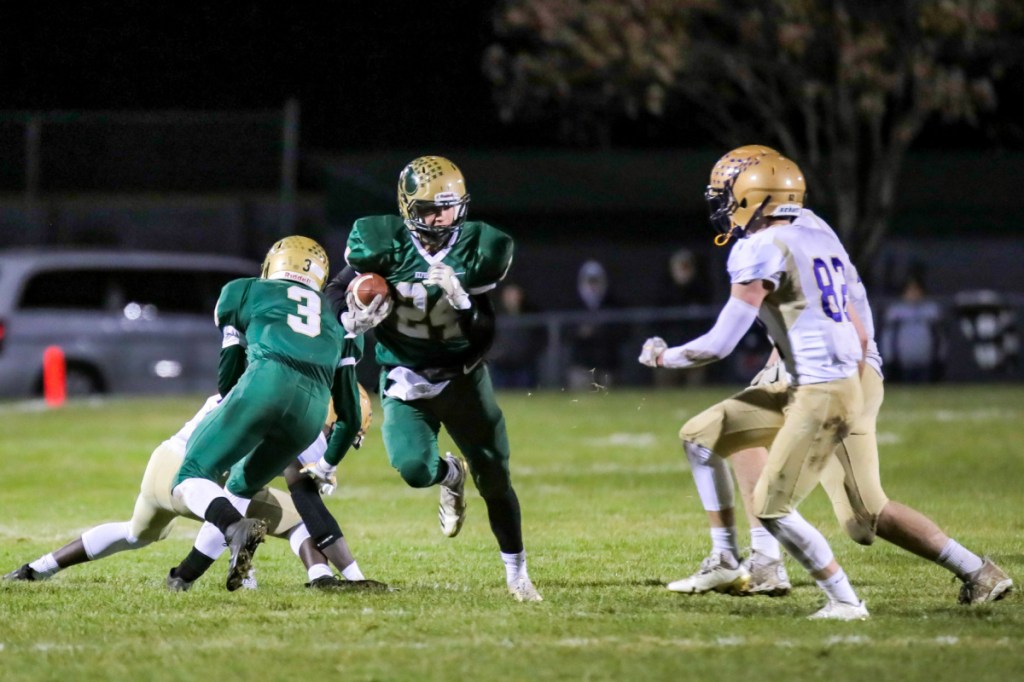 Janek Luksza of Oxford Hills tries to get past Sean Tompkins of Cheverus during their Class A North semifinal Saturday night. Oxford Hills won, 35-6.