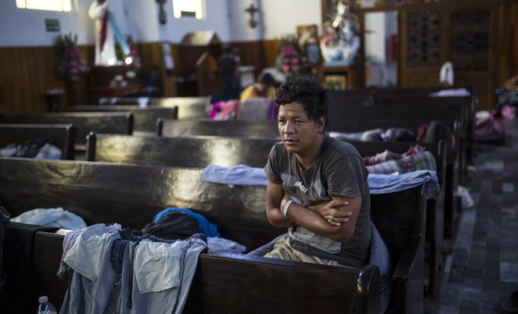 A Central American migrant wakes up Sunday in a church in Puebla, Mexico, that housed caravan members who separated from the main group.