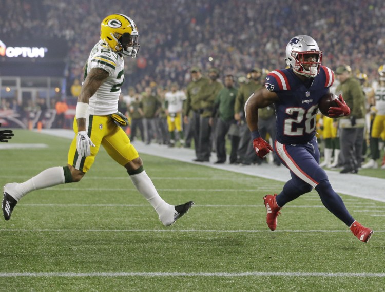 James White of the New England Patriots zips past Green Bay Packers cornerback Jaire Alexander for an 8-yard touchdown run Sunday night during the first quarter at Foxborough, Mass.