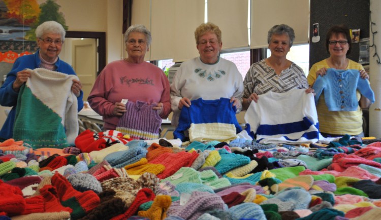Knitting for Charity members, from left, Sister Theresa Couture, Paulette Ruel, Judy Kenny, Connie Vadnais and Louise Bosse display items the group has made at the J. Richard Martin Community Center in Biddeford on Monday.