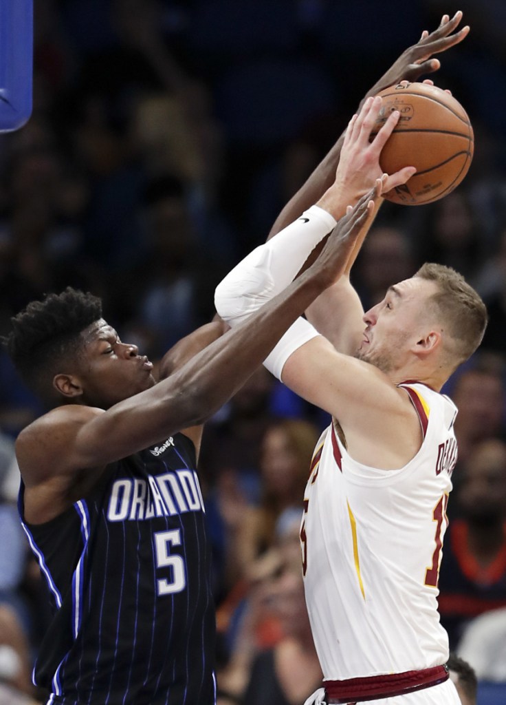 Orlando's Mohamed Bamba, left, fouls Cleveland's Sam Dekker during their game Monday night in Orlando, Fla. Evan Fournier hit a jumper at the buzzer and the Magic won 102-100.