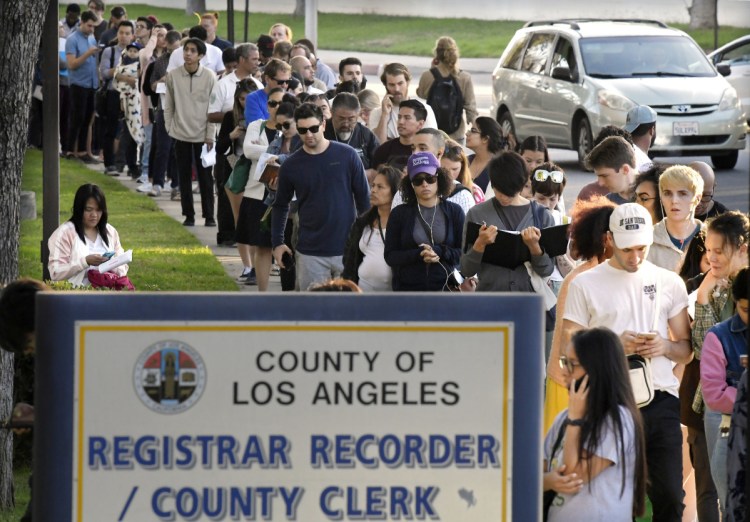 Potential voters wait in long lines to register and vote at the Los Angeles County Registrar's office Tuesday in Los Angeles. A spokesman with the registrar's office says the wait at its headquarters was about two hours.