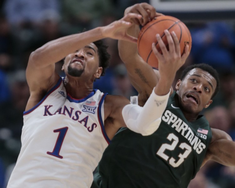 Kansas forward Dedric Lawson, left, battles with Michigan State forward Xavier Tillman during Tuesday's game in Indianapolis.