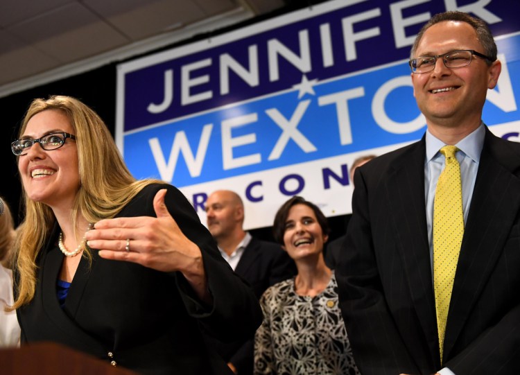 Democrat Jennifer Wexton talks to supporters flanked by her husband, Andrew, Tuesday in Dulles, Va. Wexton beat incumbent Barbara Comstock in Virginia's 10th Congressional District.