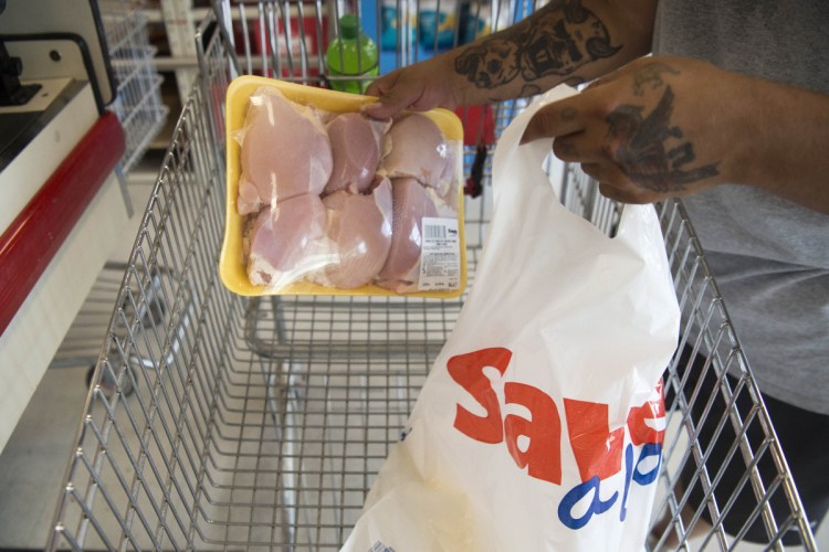 Greg Ouellette puts his groceries into a plastic bag on Aug. 15 at the Save-A-Lot store in Waterville. In Tuesday's election, Waterville residents voted to ban plastic bags by stores that are 10,000 square feet or larger.