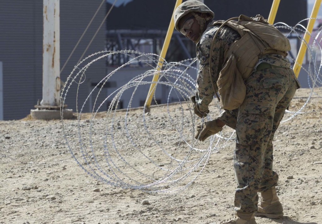 Marine Corps engineers put up razor wire near the San Ysidro Port of Entry where trains pass from the U.S. to Mexico and Mexico to the U.S. on Tuesday.