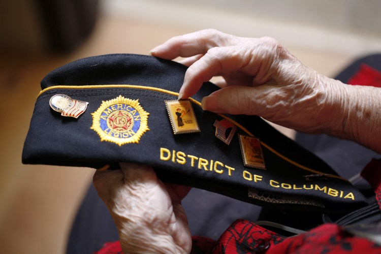 Norma Merrill displays the buttons on her American Legion cap. After retiring, Merrill helped migrant children in Florida and spent countless hours raising money for the Washington D.C. memorial for servicewomen and to support fellow veterans, many of whom were homeless.