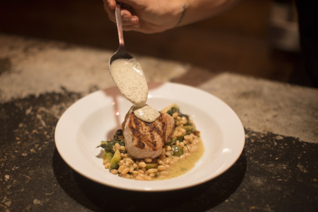 Mustard dill creme tops the precisely balanced pork loin with white navy beans.