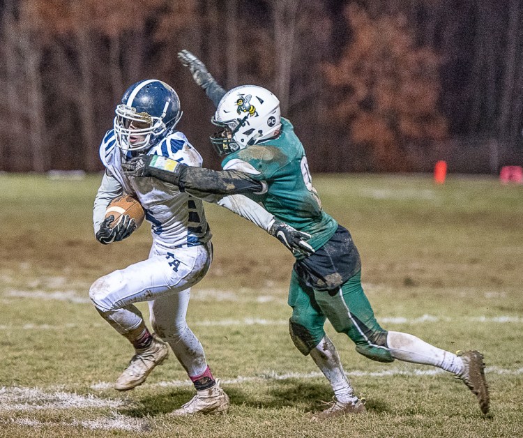 Fryeburg Academy's Dawson Jones is tackled by Damien Calder of Leavitt during the Class C South championship game Saturday night in Turner.