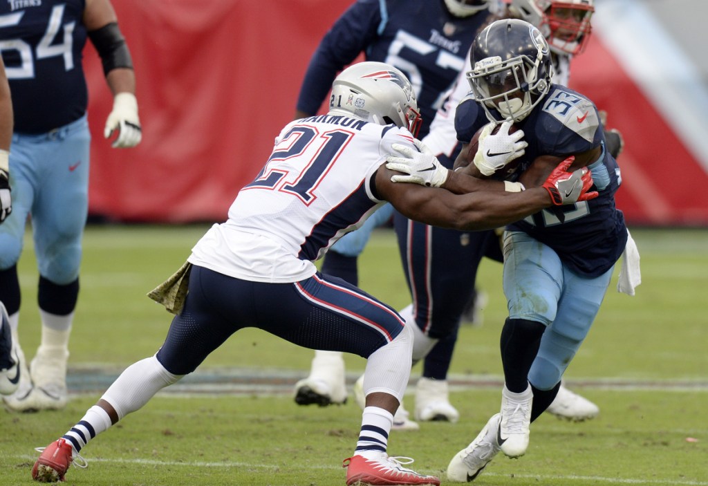 Tennessee Titans running back and former New England Patriot Dion Lewis tries to get around strong safety Duron Harmon in the second half of Sunday afternoon's 34-10 victory in Nashville.