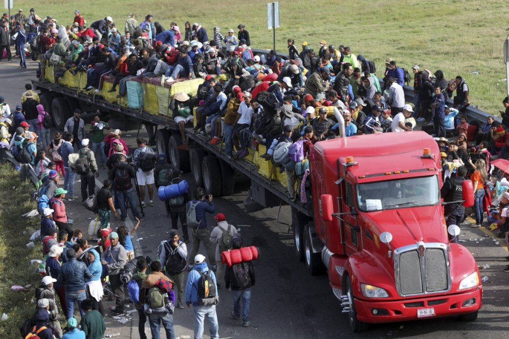 Central American migrants, part of the caravan hoping to reach the U.S. border, get a ride on a eighteen wheeler pulling a trailer, in Irapuato, Mexico, Monday, Nov. 12, 2018. Several thousand Central American migrants marked a month on the road Monday as they hitched rides to the western Mexico city of Guadalajara and toward the U.S. border. (AP Photo/Rodrigo Abd)