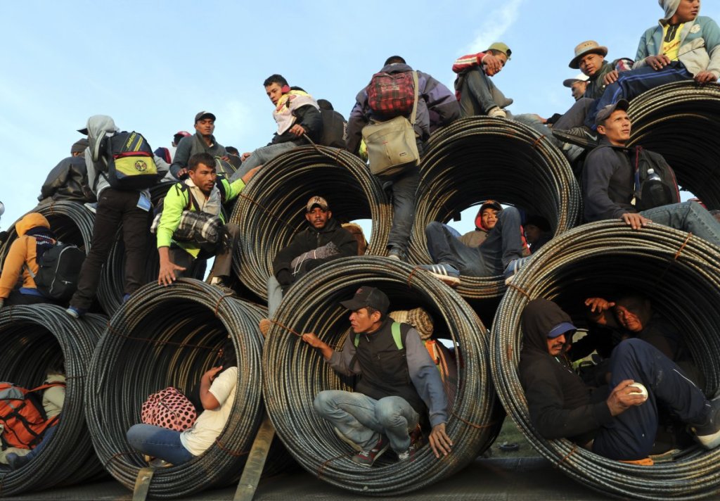 Central American migrants, part of the caravan hoping to reach the U.S. border, ride on a truck carrying rolls of steel rebar, in Irapuato, Mexico, on Monday. The migrants started out a month ago walking, but increasingly rely on getting rides.