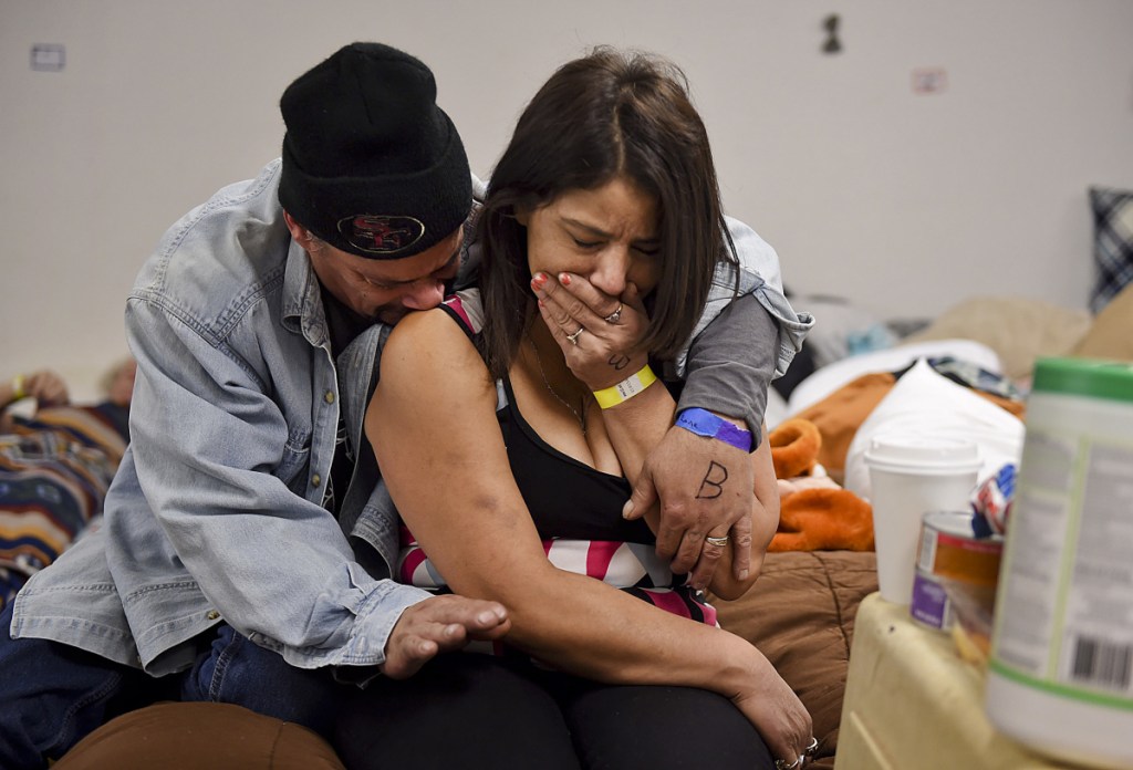 Joseph Grado and his wife, Susan Grado, embrace while staying at a shelter for fire victims at East Avenue Church on Nov. 12 in Chico, California. They lost their Paradise home in the Camp Fire. The shelter is staffed by a doctor and nurses from Feather River Hospital, who are volunteering despite being fire victims themselves.