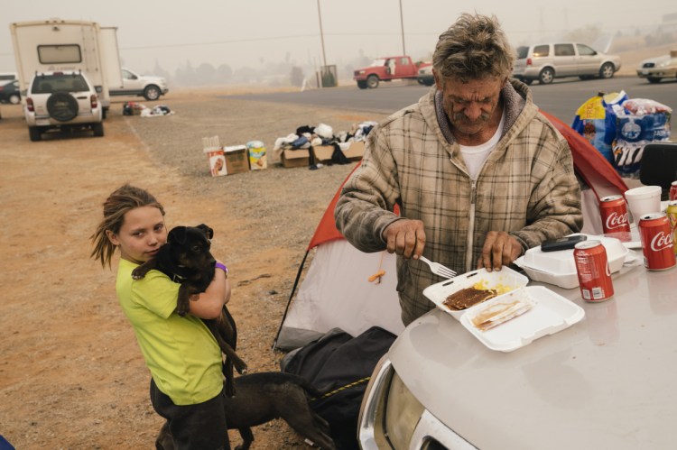 After fleeing the Camp Fire, auto mechanic David Neeley of Berry Creek, Calif., and his 10-year-old daughter, Faith, are holed up at the Red Cross evacuation center at the Church of the Nazarene in Oroville, Calif., on Tuesday.