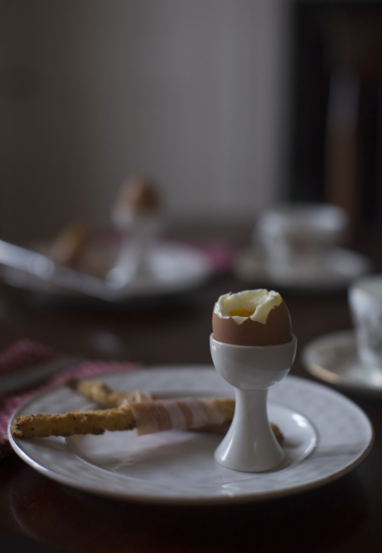 Soft-boiled eggs with prosciutto and cheese soldiers served with tea. The soldiers, for dipping in the eggs, are made from pie dough scraps, a great way to make use of the trimmings from holiday pies.