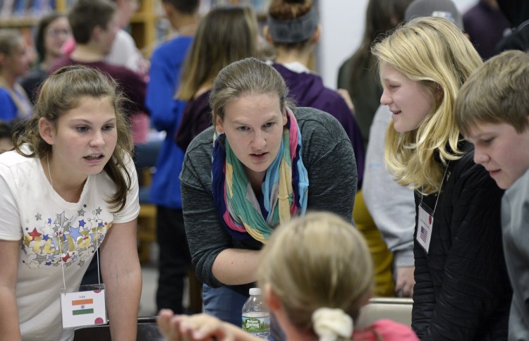 Anna McGinn, center, leads a simulation of the global summit on climate change with seventh-gragers at Loranger Middle School in Old Orchard Beach on Nov. 5. From left are Sarah Davis, McGinn, Lyla Kuchenbecker and Gabe Edwards.