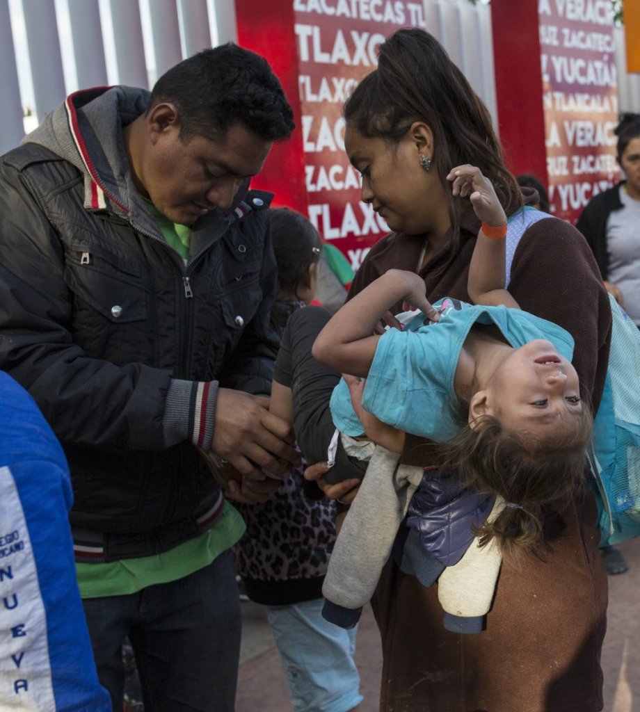 A Central American family, left, waits in line to begin the asylum process in Tijuana, Mexico in November. 