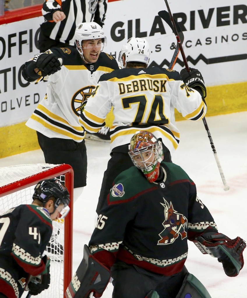 Jake DeBrusk celebrates his first-period goal with Brad Marchand during the Bruins' 2-1 win Saturday night against the Arizona Coyotes. Boston improved to 1-1-1 on a four-game road trip.