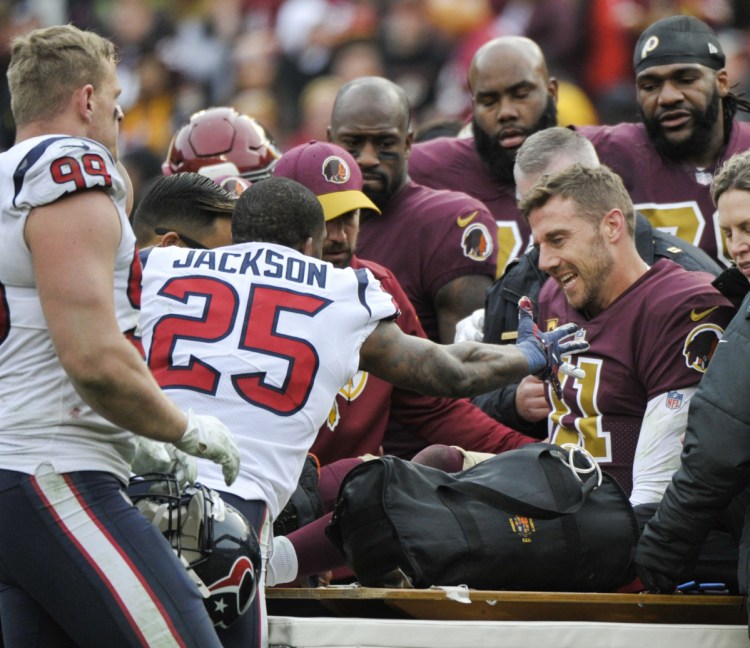 Washington quarterback Alex Smith is consoled by Kareem Jackson of the Texans after his season-ending injury Sunday.