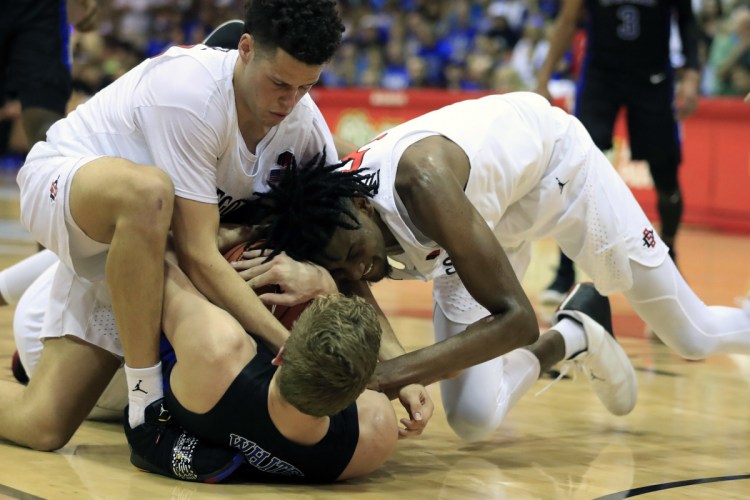 Duke forward Jack White (41) tries to hold on to a rebound as San Diego State guard Jordan Schakel (20) and forward Jalen McDaniels (5) try to wrestle it away during the first half of an NCAA college basketball game at the Maui Invitational, Monday, Nov. 19, 2018, in Lahaina, Hawaii. (AP Photo/Marco Garcia)