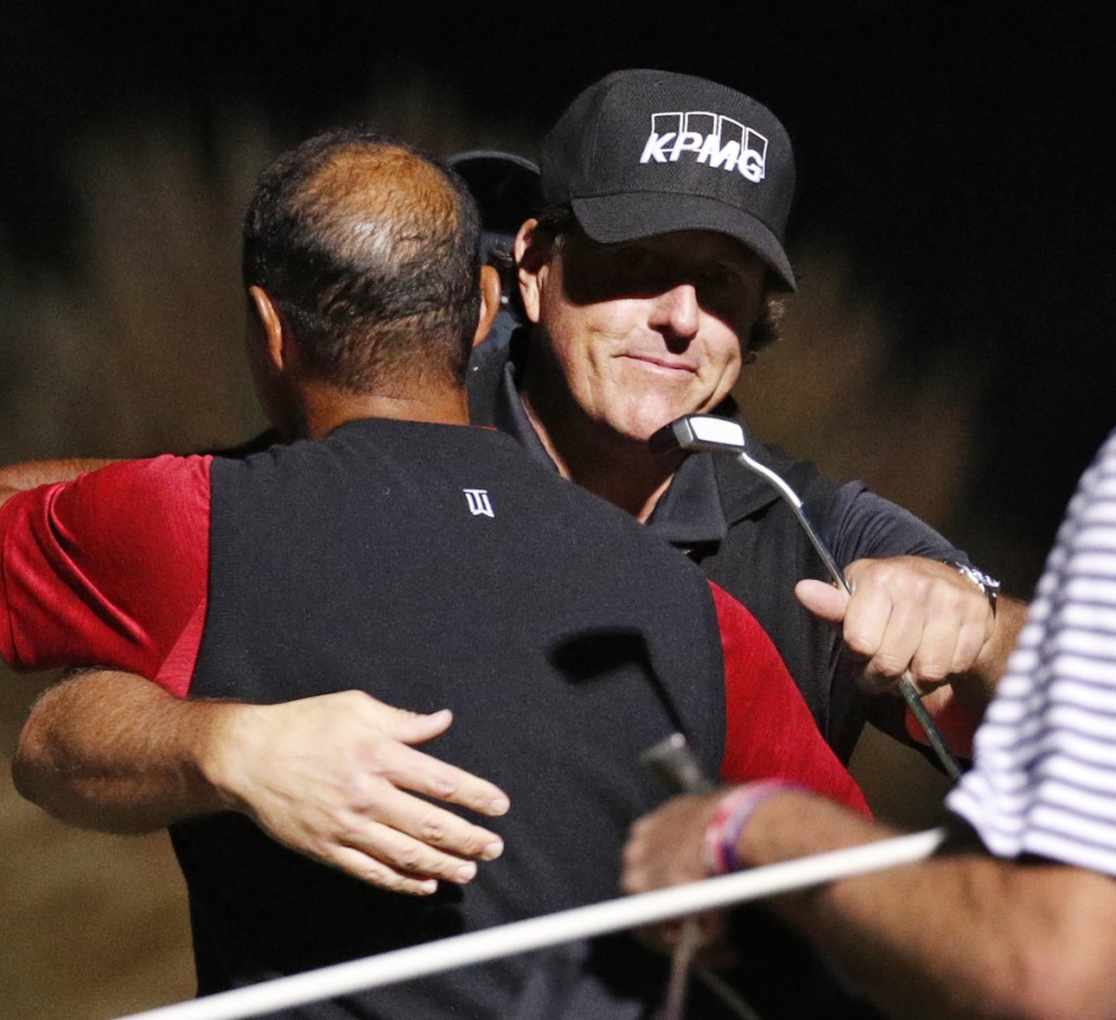 Phil Mickelson, right, hugs Tiger Woods after Mickelson won their made-for-TV match on the 22nd hole on Friday in Las Vegas.