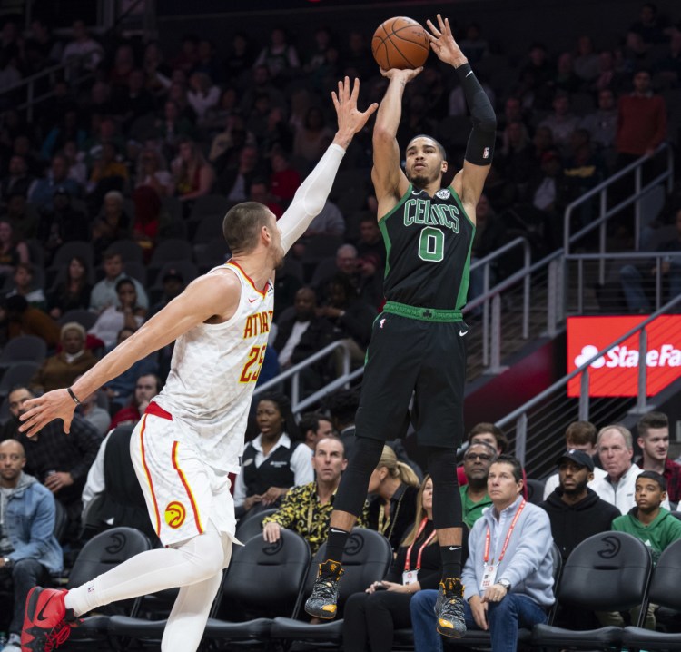 Boston Celtics forward Jayson Tatum shoots as Atlanta Hawks center Alex Len defends during the first half of the Celtics' 114-96 win Friday in Atlanta.