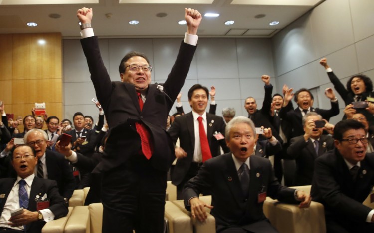 The Japanese delegation celebrates after winning the vote at the 164th General Assembly of the Bureau International des Expositions in Paris on Friday. Osaka beat out cities in Russia and Azerbaijan.