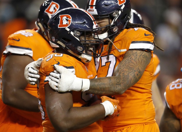 Broncos defensive end Shelby Harris, left, celebrates with Billy Turner after an interception in the end zone by Harris clinched Denver's 24-17 win Sunday against the Pittsburgh Steelers.