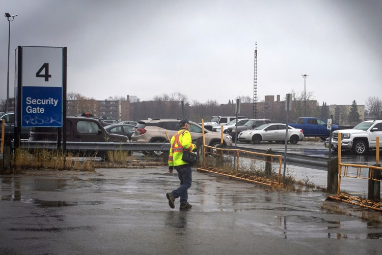 A worker leaves Oshawa's General Motors plant Monday. General Motors will lay off thousands of factory and white-collar workers in North America and put five plants up for possible closure as it restructures to cut costs and focus more on autonomous and electric vehicles. General Motors is closing the Oshawa plant.