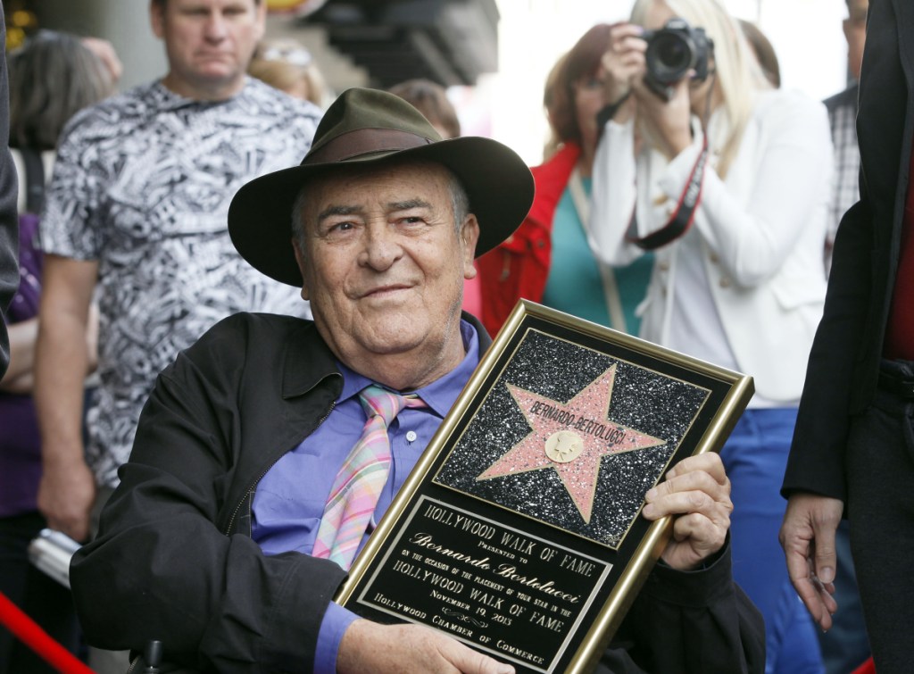 Italian director Bernardo Bertolucci makes a rare visit to his star on the Hollywood Walk of Fame in Los Angeles in 2013. He died Monday at 77.