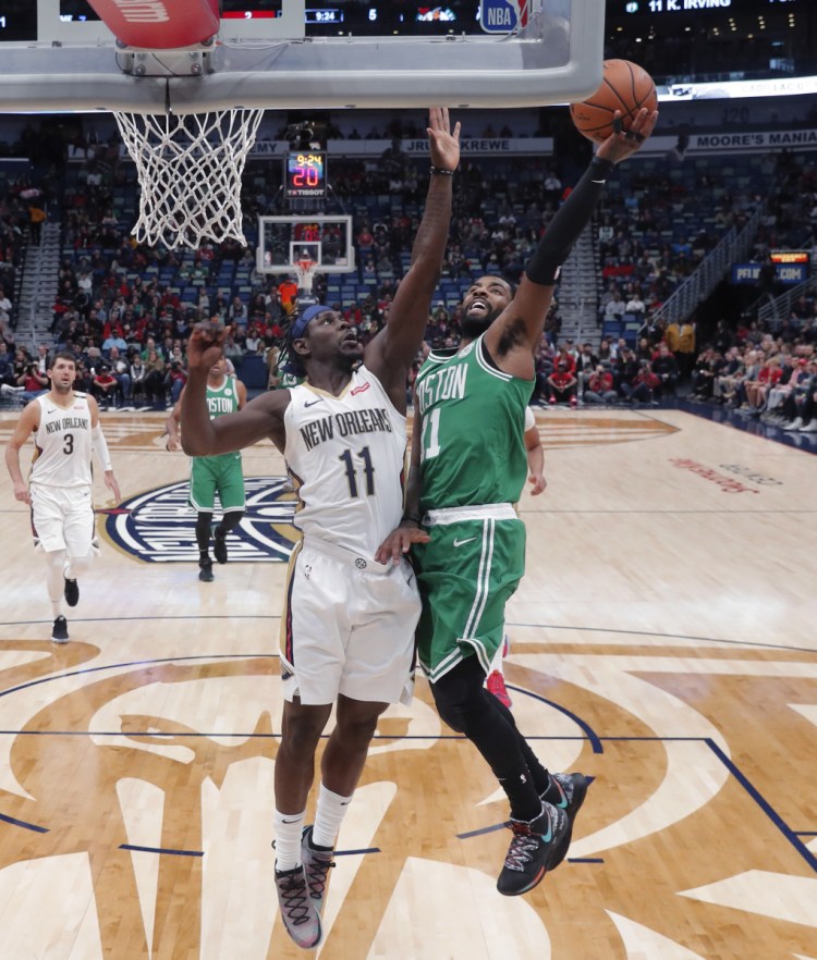 Boston Celtics guard Kyrie Irving, front right, goes to the basket against New Orleans Pelicans guard Jrue Holiday, front left, in the first half of an NBA basketball game in New Orleans, Monday, Nov. 26, 2018. ()