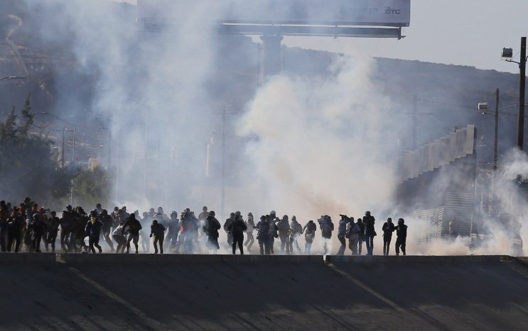 Tear gas is used to prevent migrants kept in limbo by the Trump administration from rushing the U.S.-Mexico border Sunday.