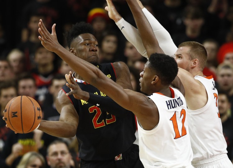 Maryland's Bruno Fernando, left, looks for a teammate as he is pressured by De'Andre Hunter, center, and Jack Salt during Virginia's 76-71 win Wednesday.