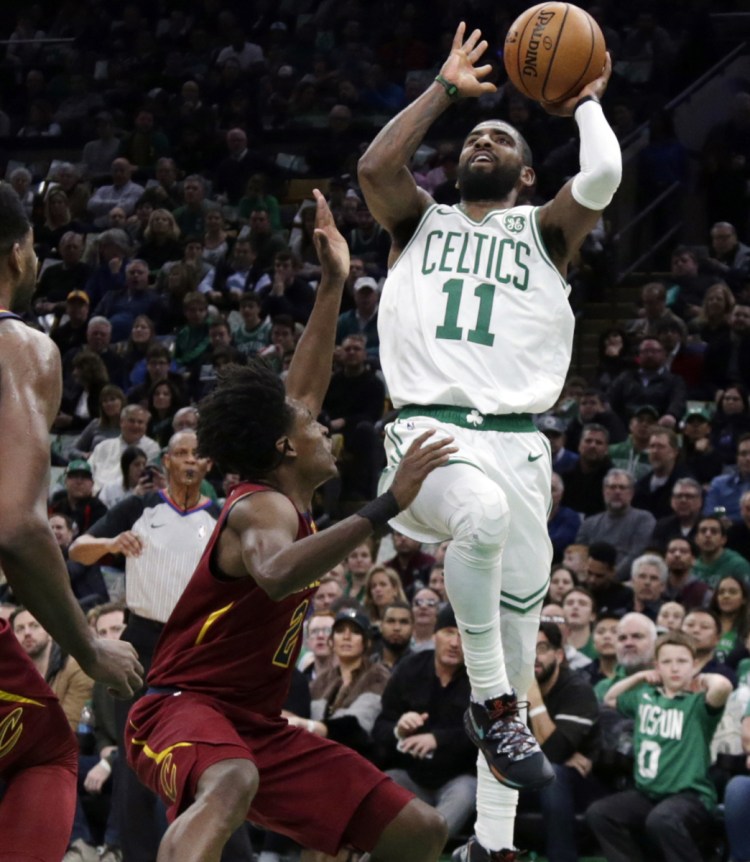 Kyrie Irving, who finished with 29 points in three quarters for the Boston Celtics, shoots over Collin Sexton of Cleveland during Boston's 128-95 win.