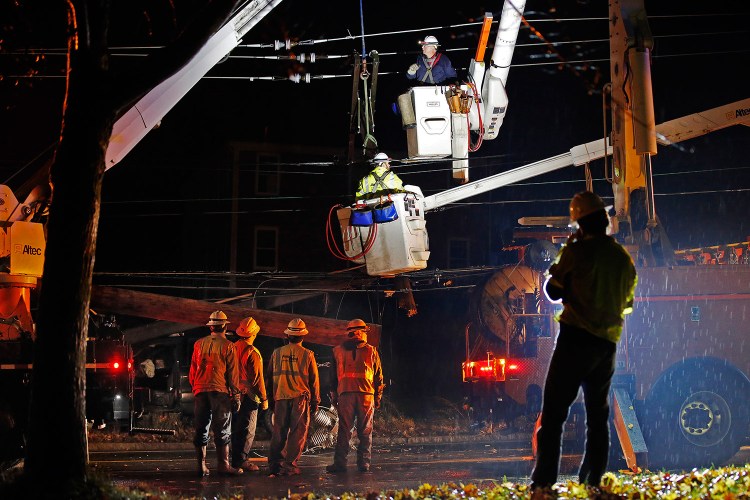 Crews work Tuesday night to repair the utility pole that was broken when a car crashed into it. A section of outer Congress Street in Portland was closed during the repair, and power was out at the Portland International Jetport and nearby areas.
