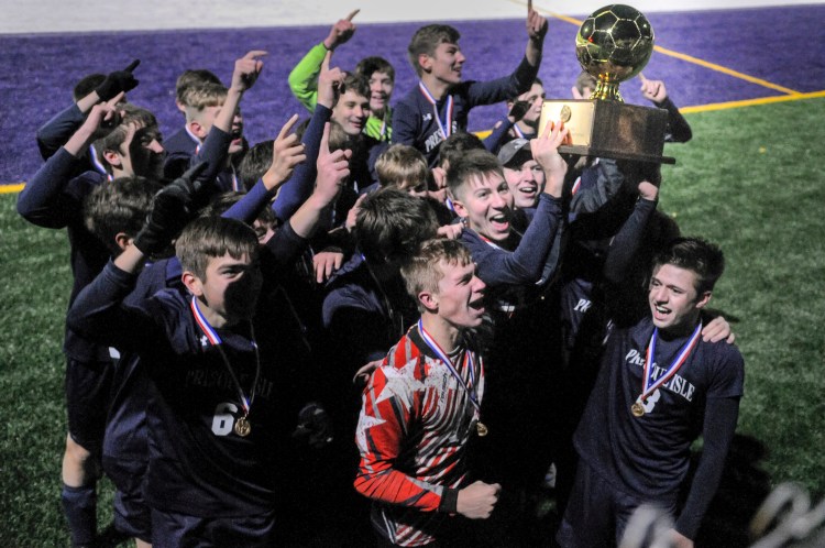 Presque Isle celebrate with the gold ball trophy after beating Freeport 3-2 in the Class B boys soccer state championship on Saturday in Hampden. 