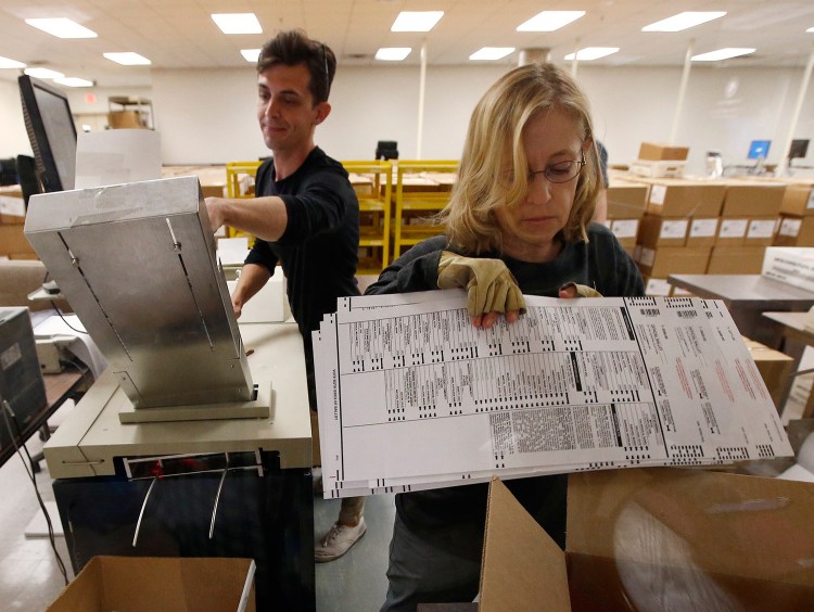 Workers organize ballots at the Maricopa County Recorder's Office in Phoenix on Thursday. By Friday night, one percentage point separated the candidates in the Senate race between Democrat Kyrsten Sinema and Republican Martha McSally.