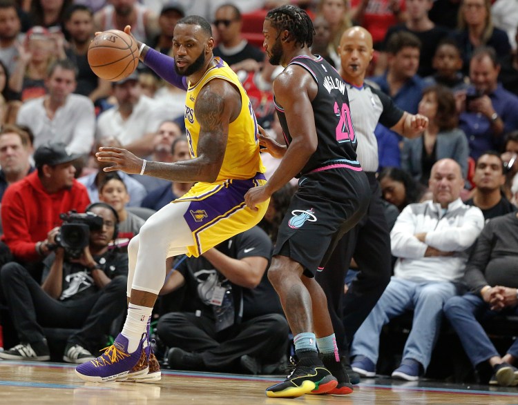 Los Angeles Lakers forward LeBron James keeps the ball away from Miami Heat center Hassan Whiteside during the second half Sunday in Miami, Fla. 
