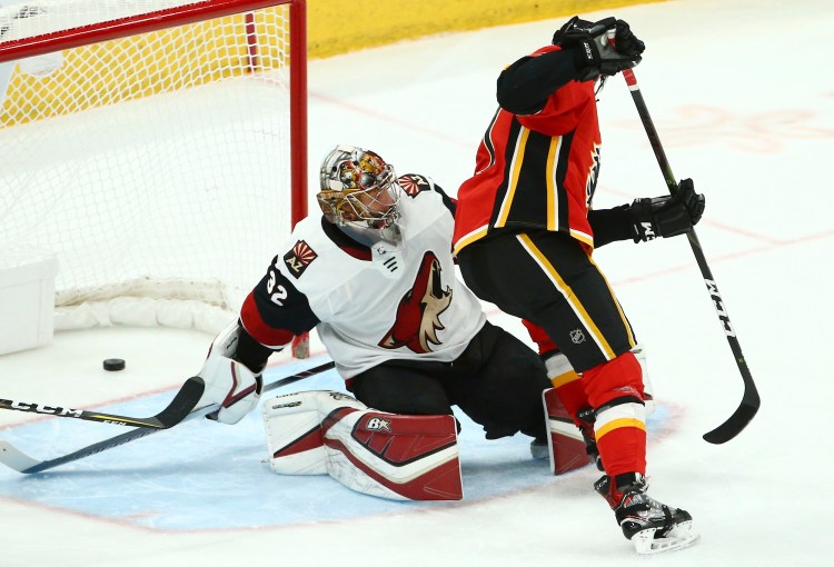 Calgary Flames center Mark Jankowski, right, scores a short-handed goal against Arizona Coyotes goaltender Antti Raanta during the third period of the Flames' 6-1 win Sunday in Glendale, Arizona.