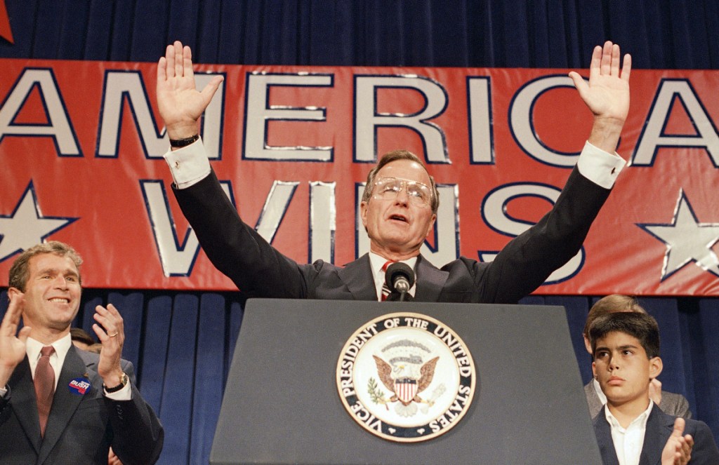 President-elect George H. W. Bush speaks at his victory rally with grandson, George P. Bush, right, and son George W. Bush, left, in Houston on Nov. 9, 1988. In one of his presidency's most memorable moments, Bush reneged on his "No new taxes" pledge, angering conservative Republicans and laying the groundwork for the GOP of today.