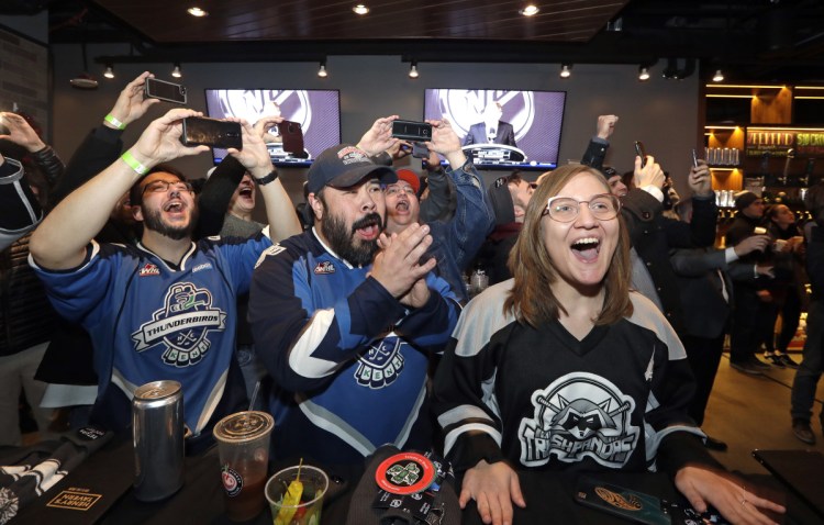 Ryan Kelly, left, Otto Rogers and Rebecca Moloney cheer the announcement of a new NHL team in Seattle at a celebratory party Tuesday. The NHL Board of Governors unanimously approved adding the league's 32nd franchise.