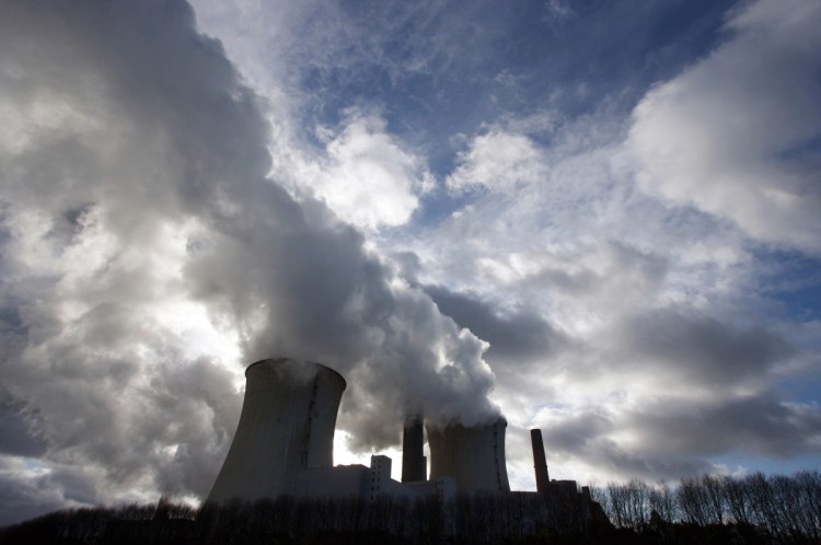 Smokestacks and cooling towers emit smoke and water vapor at a coal-fired power station in Germany.