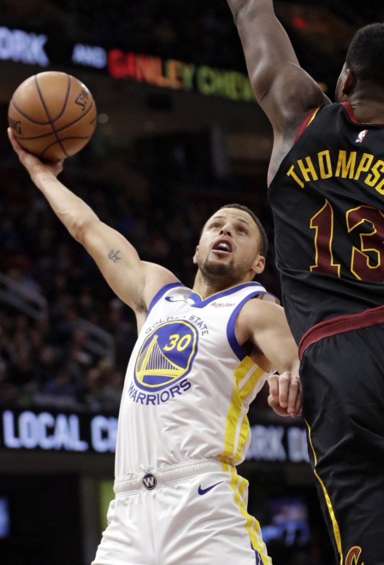 Golden State's Stephen Curry, left, drives against Cleveland's Tristan Thompson during Wednesday's game in Cleveland. The Warriors won 129-105.