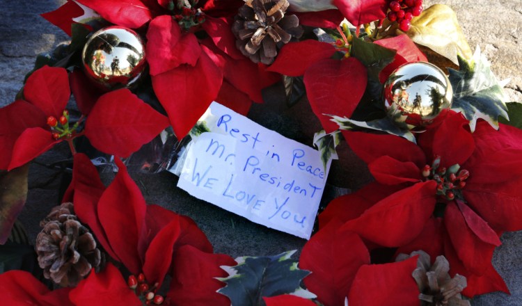 A makeshift memorial across from the Bush summer home in Kennebunkport includes this wreath and note to George H.W. Bush. A reader says he was most impressed by Bush's personal qualities.